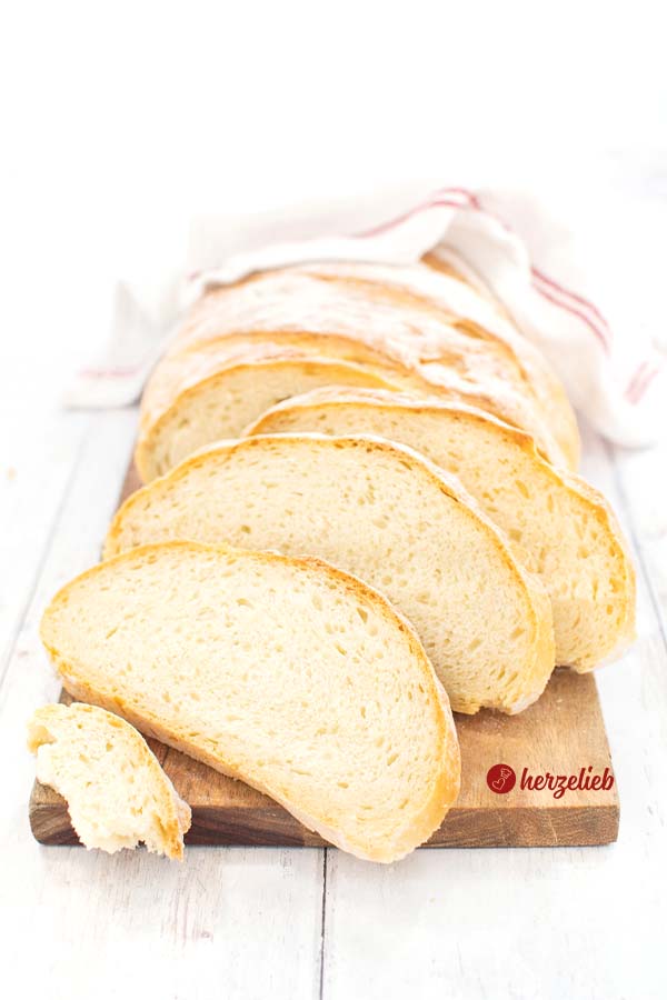 Aufgeschnittenes Kartoffel Joghurt Brot saftig, weich und superlecker - 3 Scheiben im Vordergrund und ein abgezupftes Stück