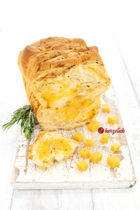 Rezept Käse-Zupfbrot mit Rosmarin und Schnittlauch. dekoriert mit Rosmarin Zweigen und Käsewürfeln
