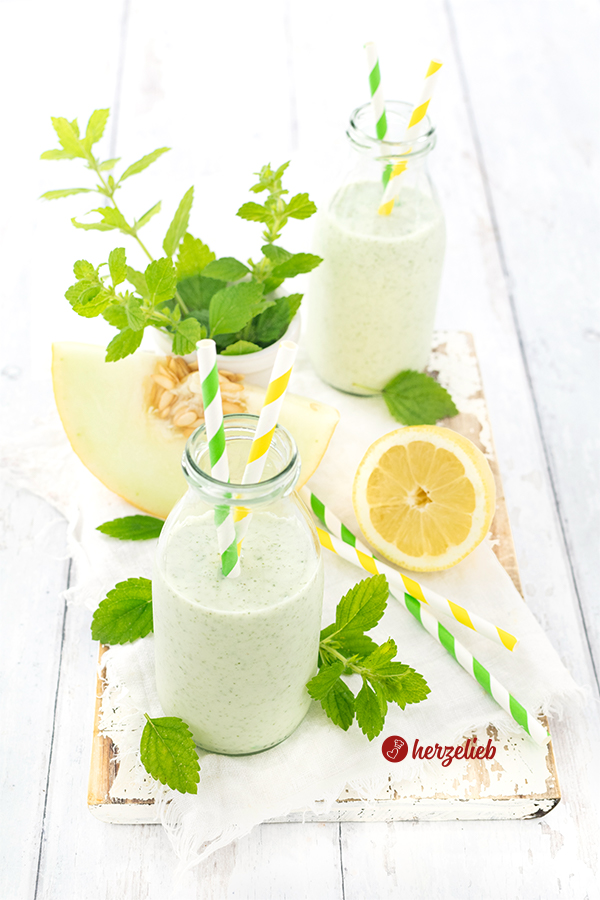  Erfrischender Melonen-Lassi Rezept mit Joghurt, Zitrone und Zitronenmelisse – Schneller Joghurtdrink. Dekoriert mit Melissenblättern und einer halben Zitrone.