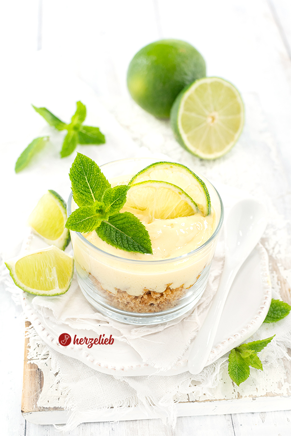 Ein Glas Limettendessert nach einem Key Time Pie Dessert Rezept von herzelieb. Dkoriert mit Limettenscheiben, Pfefferminze, ganzen und halben Limetten.