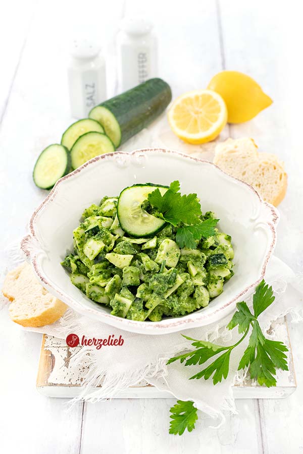 Eine Schale schneller Kohlsalat oder Gurkensalat mit grünen Dressing nach einem Grüne Göttin Salat Rezept von herzelieb. Angerichtet mit Gurke, Petersilie und Brot