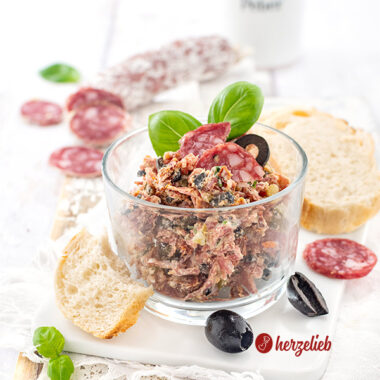 Rustami Aufstrich nach einem Salami-Brotaufstrich Rezept von herzelieb. Angerichtet mit Brot, Salamischeiben, Oliven und Basilikum.