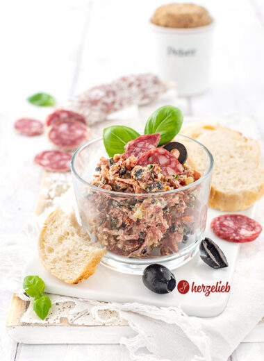 Rustami Aufstrich nach einem Salami-Brotaufstrich Rezept von herzelieb. Angerichtet mit Brot, Salamischeiben, Oliven und Basilikum.