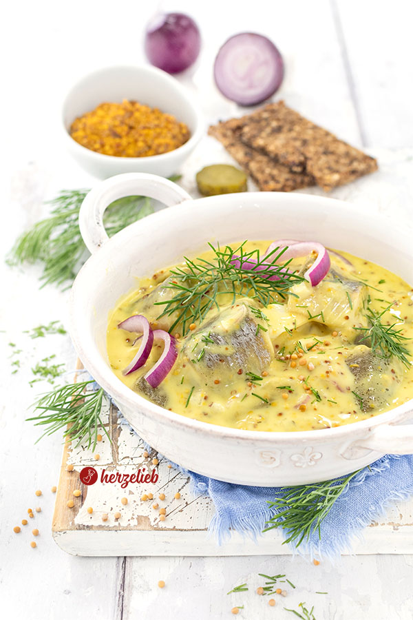Dänischer Senfhering nach einem Sennepssild Rezept von herzelieb. Der eingelegte oder marinierte Hering ist angerichtet mit Dill, roten Zwiebeln und Senfkörnern.