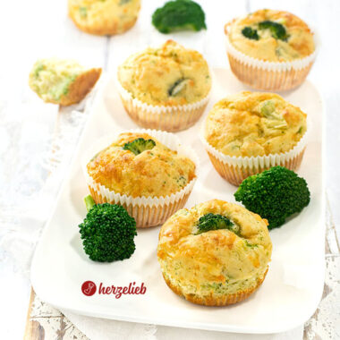 6 herzhafte Muffins nach einem Brokkoli-Käse-Muffins Rezept von herzelieb auf einem weißen Teller. Dekoriert mit Brokkoliröschen.