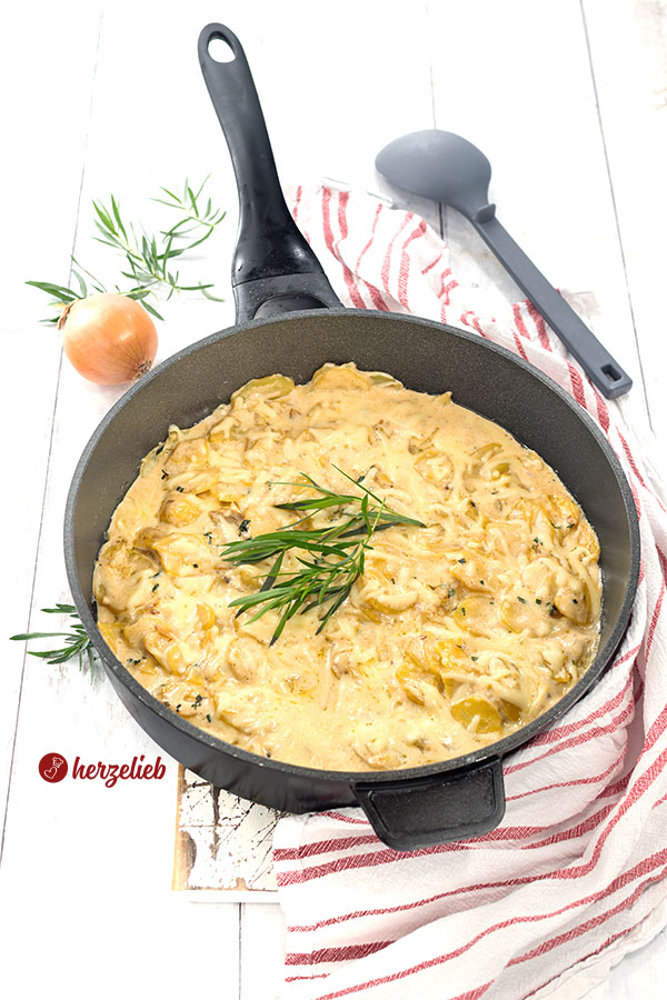 Eine Pfanne mit Flødekartofler. Mit Käse überbacken, mit Estragon  dekoriert. 