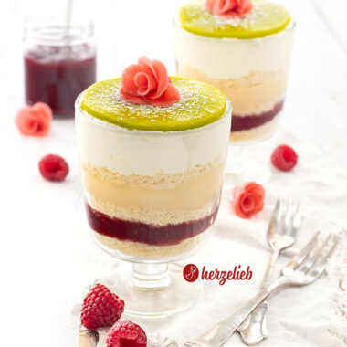 2 Schichtdesserts nach einem Prinsesstårta Dessert im Glas von herzelieb mit 5 Schichten, einem grünen Marzipandeckel, der mit Puderzucker bestäubt ist und einer rosa Rose. Die schwedische Torte als Nachtisch