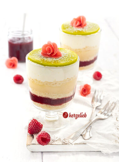 2 Schichtdesserts nach einem Prinsesstårta Dessert im Glas von herzelieb mit 5 Schichten, einem grünen Marzipandeckel, der mit Puderzucker bestäubt ist und einer rosa Rose. Die schwedische Torte als Nachtisch