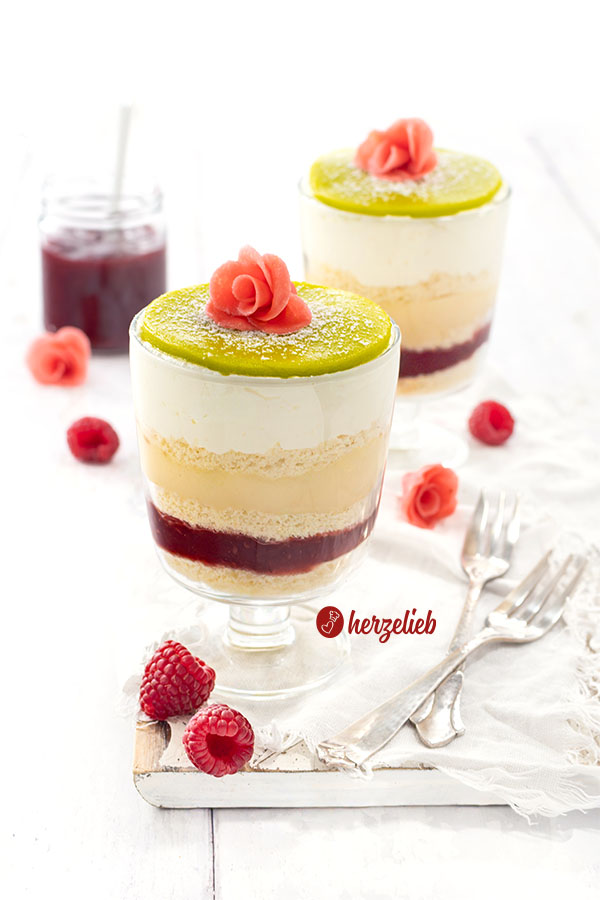 2 Schichtdesserts nach einem Prinsesstårta Dessert im Glas von herzelieb mit 5 Schichten, einem grünen Marzipandeckel, der mit Puderzucker bestäubt ist und einer rosa Rose. Die schwedische Torte als Nachtisch 