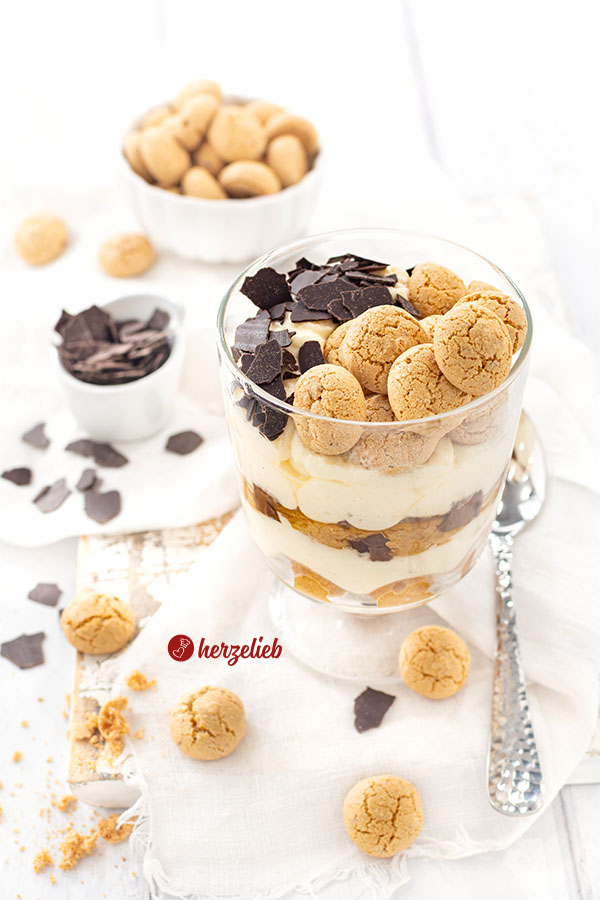 Ein Schichtdessert im Glas nach einem Präsidentencreme Rezept von herzelieb. Es besteht aus 4 Schichten und ist obendrauf mit Amarettini und Schokoraspeln dekoriert.