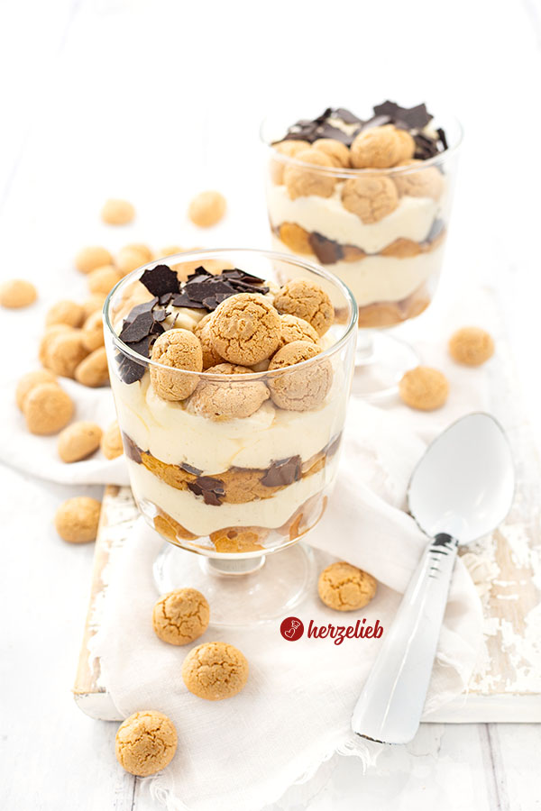 Zwei Gläser mit einem Schichtdessert, die hintereinander versetzt stehen. Das Dessert im Glas hat den Namen Präsidentencreme.