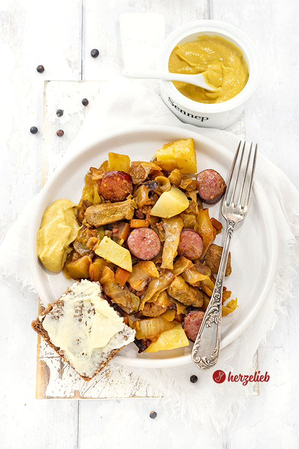 Ein Teller mit Sømandskål aus Dänemark nach einem Kohleintopf Rezept von herzelieb. Im Gericht sieht man Kartoffeln, Kohlwurst, Filetstücke, Weißkohl und Möhren