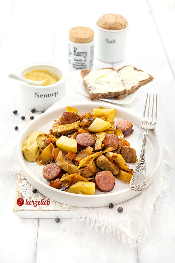Deftiger Kohleintopf nach einem Sømandskål Rezept aus Dänemark von herzelieb mit Kohl, Karotten, Kohlwurst, Kartoffeln und Filetstücken auf einem weißen Teller angerichtet.