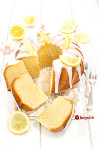 Angeschnittener Joghurt-Zitronen-Gugelhupf. Mit Zuckerguss und Zitronen dekoriert