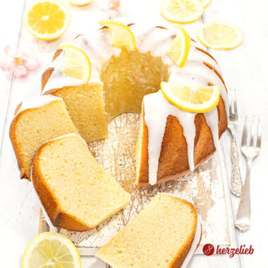 Angeschnittener Joghurt-Zitronen-Gugelhupf. Mit Zuckerguss und Zitronen dekoriert