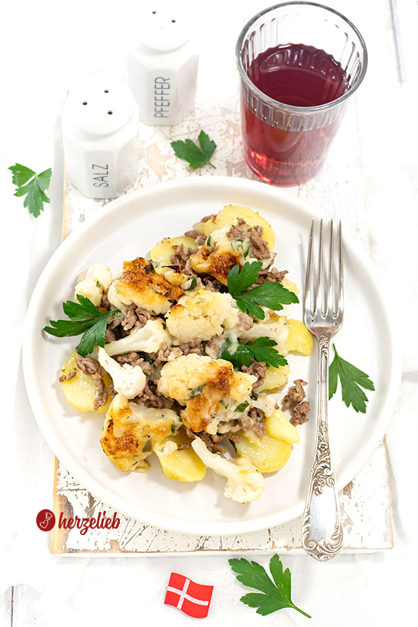 Samsøfad aus Dänemark mit Hackfleisch, Kartoffeln und Blumenkohl auf einem Teller. Von oben fotografiert, auf dem Tellerrand eine Gabel.