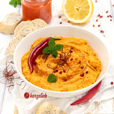 Schneller Balkan-Dip in einer Schale. Dekoriert mit Chili und Kräutern, serviert mit Brot