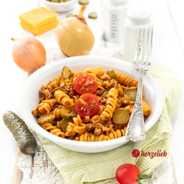 Nudeltopf mit Käse und sauren Gurken in einer Schale nach einem Cheeseburger-Pasta Rezept von herzelieb.
