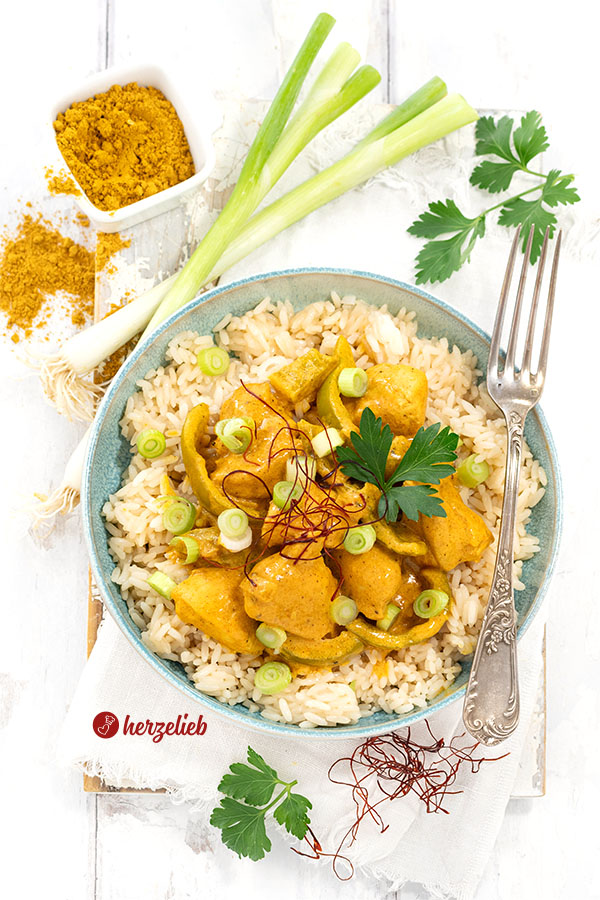 Würzige Geflügelpfanne mit Reis in einer Schale nach einem Curry-Schmand-Hähnchen Rezept von herzelieb