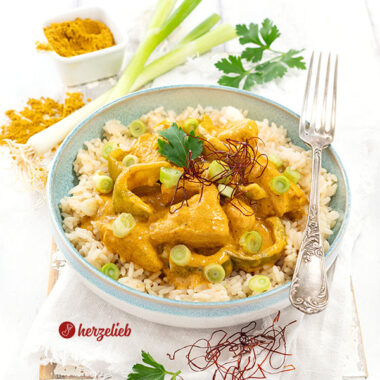 Schnelle Hähnchenpfanne mit Curry nach einem Curry-Schmand-Hähnchen Rezept von herzelieb. Serviert mit Reis, dekoriert mit Petersilie und Chilifäden.