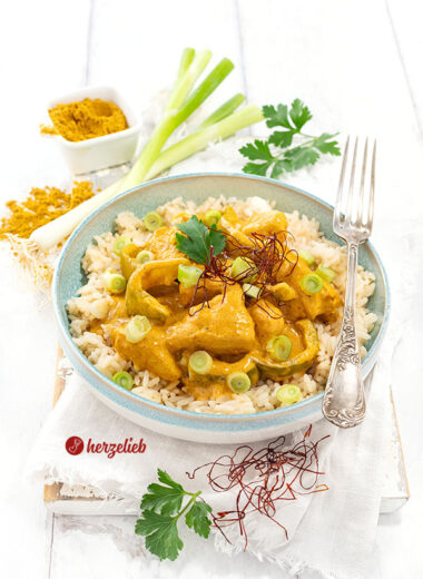 Schnelle Hähnchenpfanne mit Curry nach einem Curry-Schmand-Hähnchen Rezept von herzelieb. Serviert mit Reis, dekoriert mit Petersilie und Chilifäden.