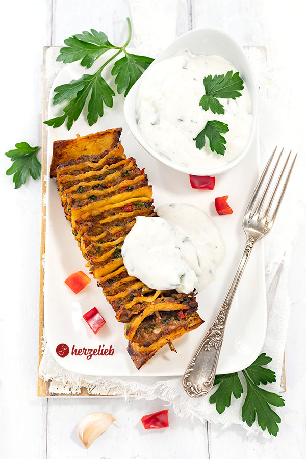 Fingerfood nach einem Kebabspieße Rezept von herzelieb. Angerichtet mit Tzatziki auf einem Teller. Dekoriert mit Petersilie.