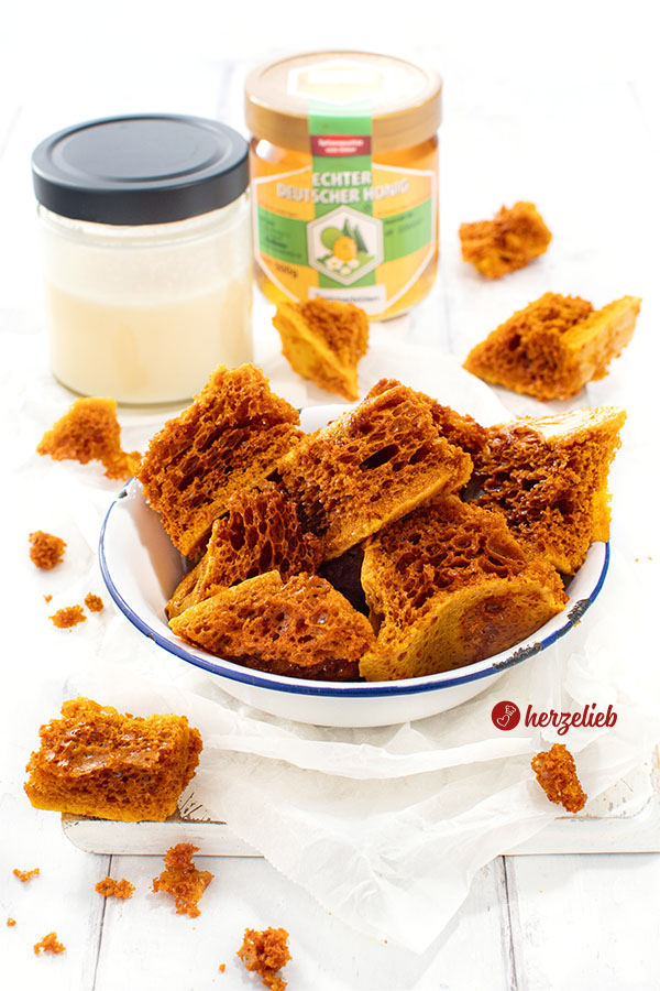 Emaille-Schüssel mit knusprigen Bienenkaramell nach einem Honeycomb Rezept von herzelieb. Im Hintergrund 2 Honiggläser