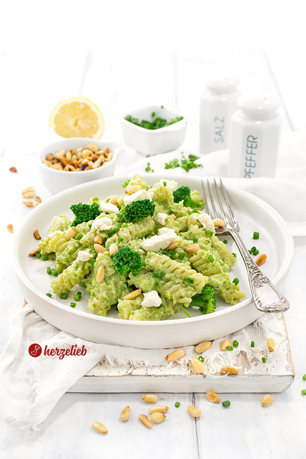 Ein Teller mit Brokkoli-Pasta mit Feta, Pinienkernen und Brokkoliröschen