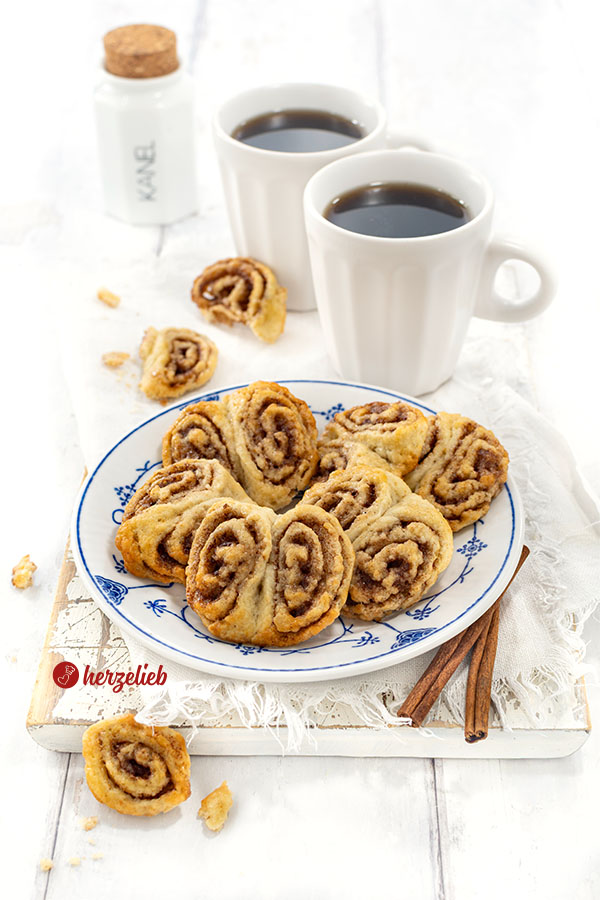 Ein Teller mit Plätzchen nach einem Franzbrötchen-Kekse Rezept von herzelieb. Angerichtet mit zwei Kaffeebechern.