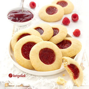 Mit Marmelade gefüllte Plätzchen nach einem Hallogrottor Rezept aus Schweden von herzelieb. Angerichtet auf einem Teller, dekoriert mit Himbeeren